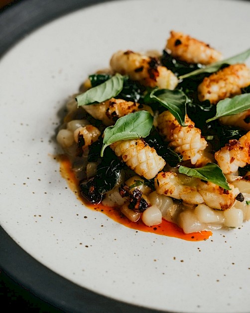 Ledok Nusa - Potato risotto, sweet corn, grilled calamari, sambal goreng, kemangi oil, and green herbs at HOME by Chef Wayan