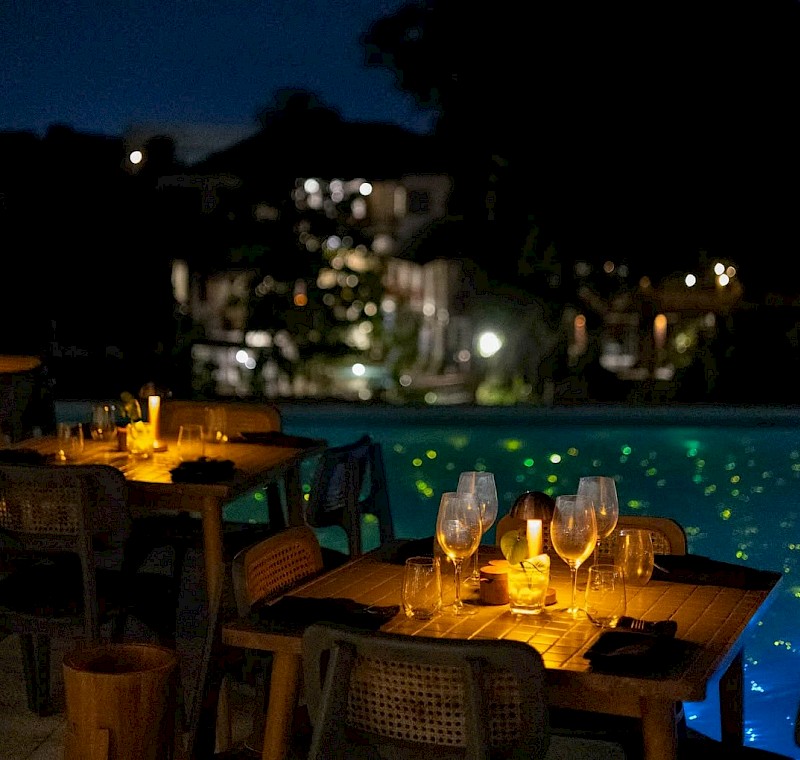 Candlelit poolside dining with sparkling water views and a serene night ambiance at Valle Canggu Padang Linjong