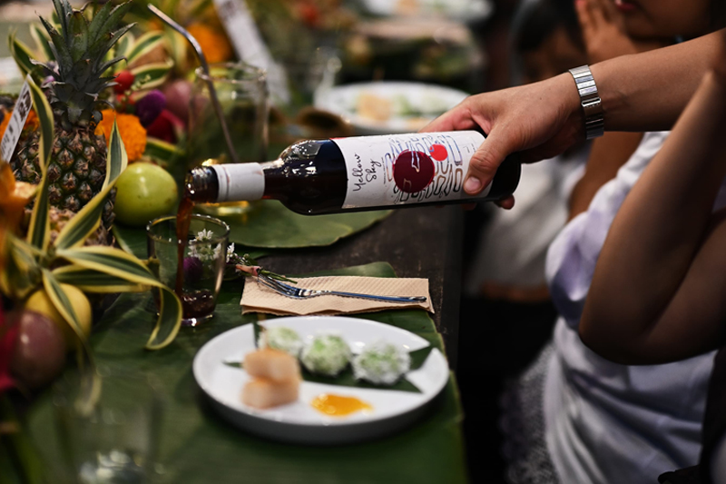 Pouring a glass of Yellow Sky Fruit Wine at a wine pairing event